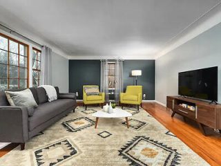 A contemporary living room with a gray sofa, two yellow armchairs, and a modern TV setup, creating a chic and comfortable space.
